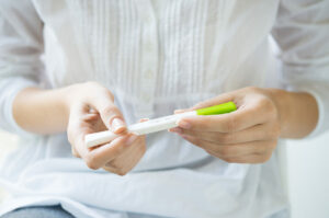 Close-up of woman's hands holding a pregnancy test.