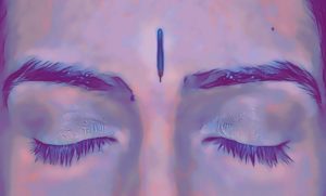 Person's face with acupuncture needle in acu point Yin Tang, between the eyebrows.